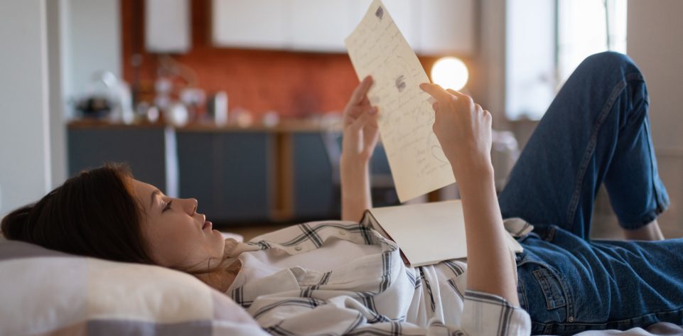 girl-reading-notes-for-exam-in-bed.jpg
