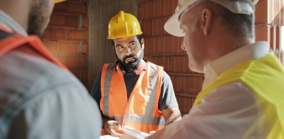 supervisor-showing-building-plans-to-workers-in-new-house.jpg